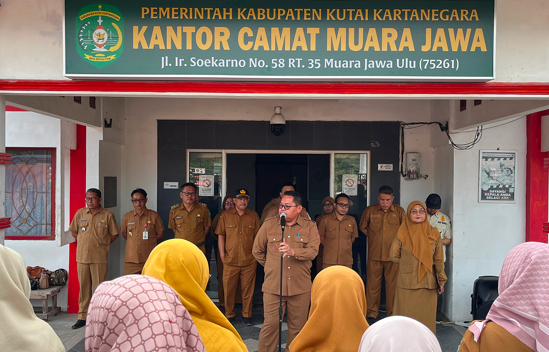 Muara Jawa, Senin 29 Juni 2026 – Pemerintah Kecamatan Muara Jawa kembali melaksanakan apel rutin hari Senin yang berlangsung di halaman Kantor Camat Muara Jawa, Senin (29/6/2026). Kegiatan apel tersebut diikuti oleh seluruh aparatur sipil negara (ASN), pegawai pemerintah dengan perjanjian kerja (PPPK), tenaga non-ASN, serta seluruh staf di lingkungan Kantor Camat Muara Jawa.

Pada pelaksanaan apel kali ini, bertindak sebagai pembina apel adalah Camat Muara Jawa, Muhammad Rami, S.MM. Dalam amanatnya, beliau menyampaikan sejumlah arahan penting kepada seluruh jajaran pegawai, khususnya terkait pelaksanaan salah satu program prioritas Pemerintah Kabupaten Kutai Kartanegara, yaitu Program RT-Ku Terbaik yang saat ini mulai memasuki tahapan implementasi di seluruh wilayah kecamatan.

Apel rutin setiap hari Senin tidak hanya menjadi agenda pembuka aktivitas pemerintahan di awal pekan, tetapi juga menjadi media penyampaian informasi, evaluasi, serta penguatan komitmen seluruh aparatur dalam memberikan pelayanan terbaik kepada masyarakat. Melalui forum tersebut, pimpinan dapat menyampaikan kebijakan-kebijakan terbaru sekaligus memastikan seluruh perangkat kecamatan memiliki pemahaman yang sama terhadap arah pembangunan daerah.

Dalam amanatnya, Camat Muara Jawa menjelaskan bahwa Program RT-Ku Terbaik merupakan salah satu inovasi strategis Pemerintah Kabupaten Kutai Kartanegara yang bertujuan meningkatkan kualitas pembangunan berbasis Rukun Tetangga (RT). Program ini diharapkan mampu memperkuat peran RT sebagai garda terdepan dalam pelayanan masyarakat sekaligus menjadi penggerak pembangunan yang partisipatif, transparan, dan berkelanjutan.

Beliau menegaskan bahwa keberhasilan program tersebut tidak hanya bergantung pada pemerintah daerah semata, melainkan membutuhkan dukungan aktif dari seluruh unsur pemerintahan hingga tingkat desa dan kelurahan. Oleh karena itu, Kecamatan Muara Jawa siap memberikan dukungan penuh agar pelaksanaan program dapat berjalan sesuai dengan tujuan yang telah ditetapkan.